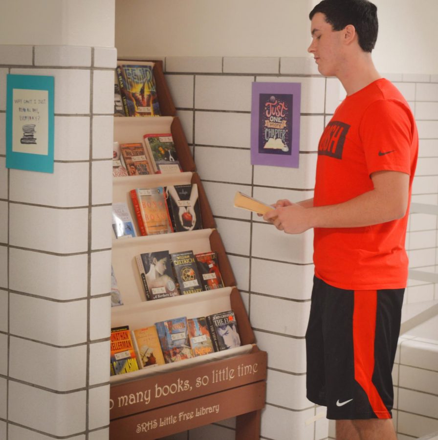 Junior Logan Croll takes advantage of the books in the new free library created by Mrs. Elford.