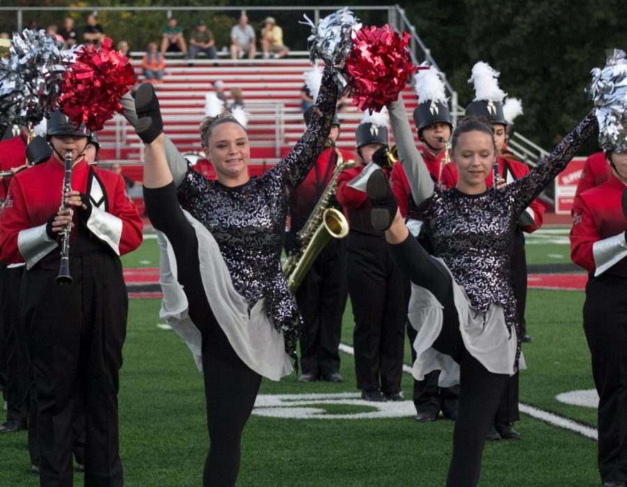 Senior Breanna Walters and junior Aizlynn Riefer dance to Fireball during the marching bands pregame performance.