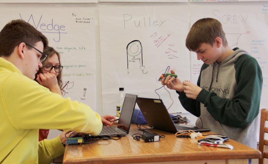 Juniors Garret Heasley, Jesse Fischer, and Shane Schettler work on programming and building their respective robots.