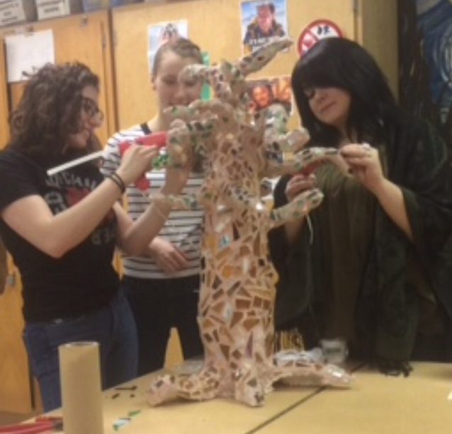 Ms. Pauletich helps seniors Ava Marini and Barbie Cessar with a tree sculpture.