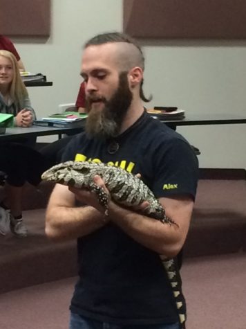 Alex Petridis holds an iguana during a TASOW presentation in the high school LGI.